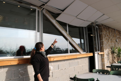 Plano general de una trabajadora mostrando los daños en el techo de un bar de la Canonja situado en la N-340.