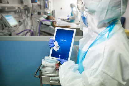 Una de las enfermeras limpia a fondo la tableta para evitar una propagación del virus a través del aparato.