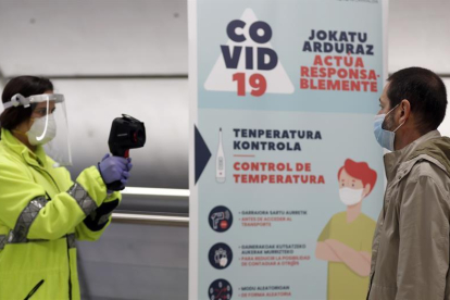 Una voluntària de la DYA pren la temperatura al metro de Bilbao.