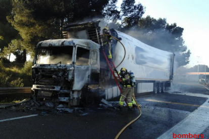 Bombers amb el camió incendiat.