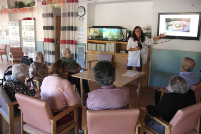 un grup d'usuaris del centre de dia de la Fundació Sant Hospital de la Seu d'Urgell duent a terme un taller de reminiscència