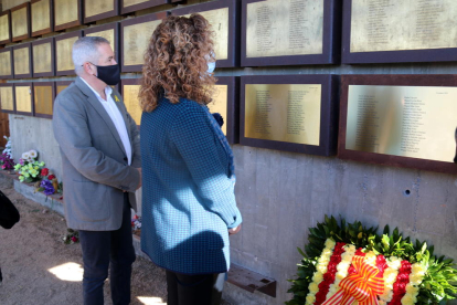 La consellera Ester Capella y el delegado del Gobierno en el Ebro, Xavier Pallarés, mirando la nueva placa del Memorial de las Camposines.