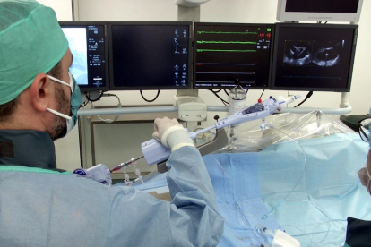 Plano medio de dos médicos del Hospital Clínic durante la colocación de un clip en la válvula tricúspide del corazón a un paciente.