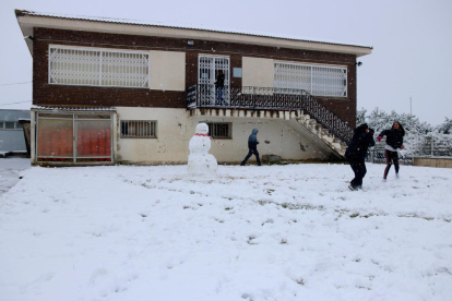 Uns nois fent una guerra de boles de neu durant el temporal, a Gandesa.