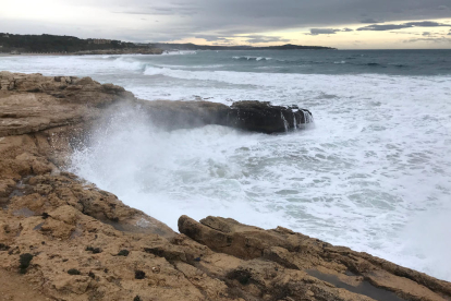 Pla general de les onades impactant contra les roques, a prop de la platja de l'Arrabassada.