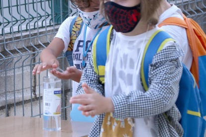 Dos alumnes de primària rentant-se les mans amb gel hidroalcohòlic a l'accés de l'escola Sant Llàtzer de Tortosa.
