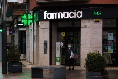 Imagen de una mujer saliendo de una farmacia en Tortosa.