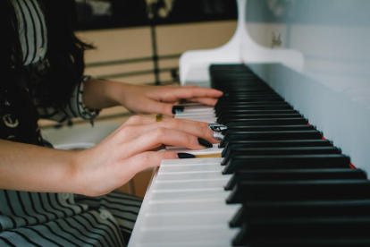 Imagen de archivo de una mujer tocando un piano.