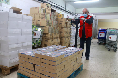 Un voluntari de Creu Roja Tarragona deixant a punt el magatzem d'aliments.