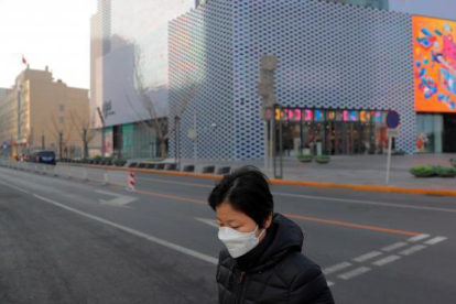 Una mujer en una calle vacía después de la cancelación de las celebraciones de Año Nuevo en Pekin.