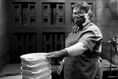 Una de las trabajadoras de la fábrica de Valira, en Reus, con guantes y mascarilla por prevención.