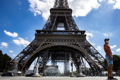 Un hombre delante de la Torre Eiffel.