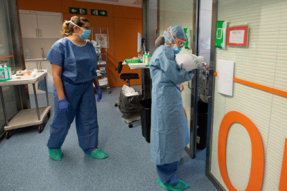 Una professional sanitària entra en una habitació ocupada per un positiu per coronavirus a l'Hospital Clínic.