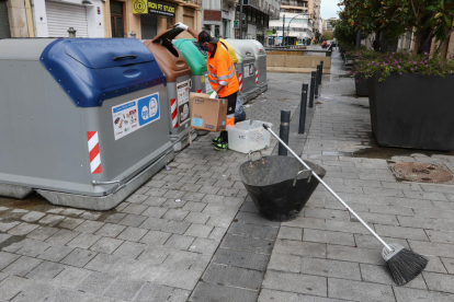 Un treballador d'FCC netejant els voltants d'un contenidor al carrer Colom de Tarragona