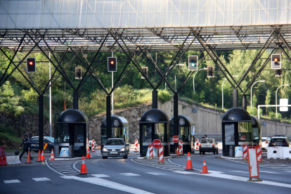 Plano de detalle de pocos vehículos entrando y saliendo del paso fronterizo que separa Andorra y Cataluña.