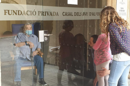 Moment del retrobament entre Nicolás Méndez amb el seu fill i les seves nétes, a les quals només ha pogut veure a través de la porta.
