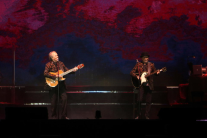 Joan Manuel Serrat i Joaquín Sabina, tots dos cantant i tocant la guitarra durant el seu concert al Palau Sant Jordi de la gira 'No hay dos sin tres'.