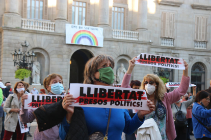 Una mujer sujeta una pancarta con el lema 'Llibertat presos polítics' en la plaza Sant Jaume de Barcelona.