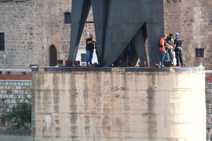 Plano general de algunos agentes de los Mossos d'Esquadra haciendo una inspección ocular sobre la explosión en la base del monumento franquista del Ebro en Tortosa.