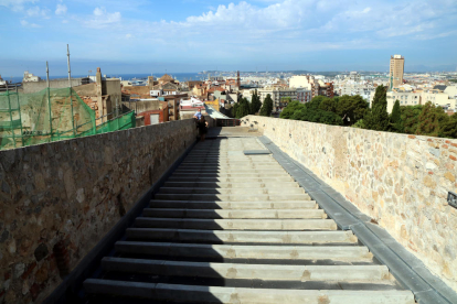 Un tram del pas de ronda de la muralla de Tarragona, a la zona de la Baixada del Roser, amb el paviment inacabat i les vistes de la ciutat al fons