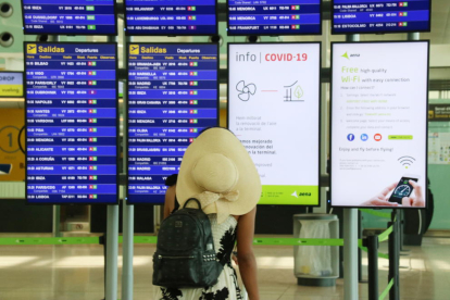 Una viatgera consultant les pantalles informatives a l'Aeroport del Prat el 31 de juliol de 2020.