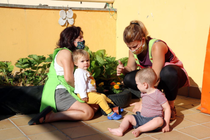 Dos profesoras con mascarilla con dos niños en el jardín de infancia del Pallars Sobirà.