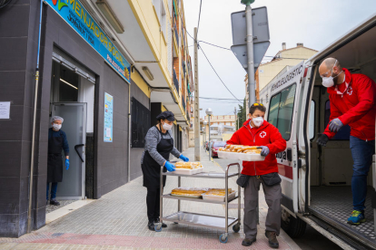 Dos membres de Creu Roja recullen aliments per portar-los al pavelló del Serrallo.