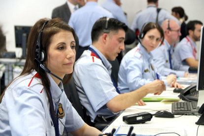 Agentes de los Mossos d'Esquadra atendiendo incidentes policiales en la sala de mando del 112.