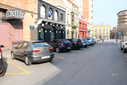 Plano general de la calle donde pasaron los hechos con los bares al lado y algunos coches aparcados.