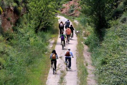 Un grup de visitants de Coma-ruga pedalejant per la via verda, a Horta de Sant Joan.