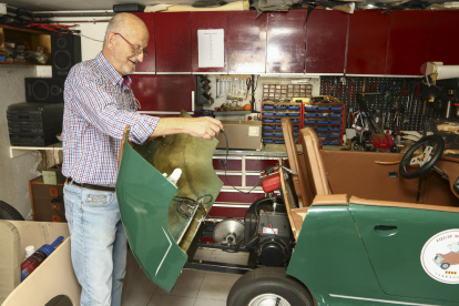 Moncusí mostrando el motor de la réplica del Porsche en el taller del garaje de su casa.