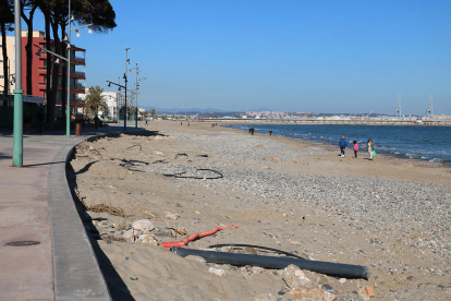 El passeig i la platja de la Pineda, a Vila-seca, plena de pedres i restes de tubs.
