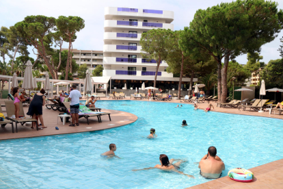 Pla general de turistes banyant-se i prenent el sol en una piscina de l'hotel Golden Port Salou & Spa