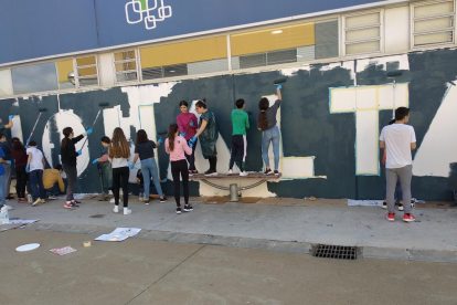 Un grup d'alumnes pintant el mur