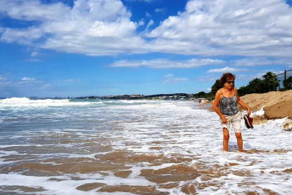 Una dona passejant per la platja.