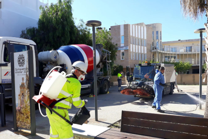Els operaris municipals i del camió-formigonera, facilitat per Cemex, durant les tasques de desinfecció als carrers d'Alcanar