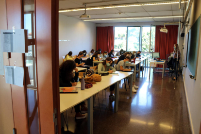 Una aula de la URV, vista des de fora, amb alumnes fent classe amb mascareta en el primer dia del curs 2020-2021.