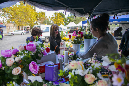 Imagen de clientes comprando flores a un puesto del Mercado de flores en el cementerio de Tarragona el día de Todos los Santos de 2018.