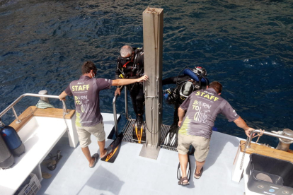 Dos submarinistas subiendo al barco del centro de buceo después de hacer una inmersión en las islas Medes.