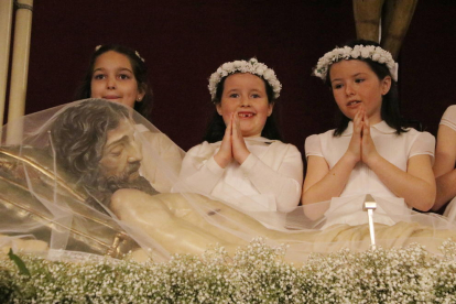 Pla mig de tres nenes vestides de comunió durant la Coronació del Senyor a Reus, davant del Crist Rei.