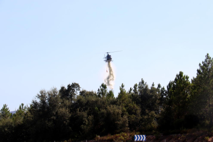Un helicòpter sobrevolant la zona afectada per l'incendi forestal.