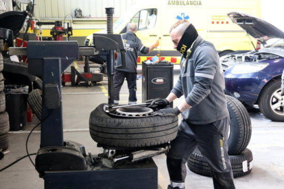 Un mecànic repara un pneumàtic, en un taller del polígon Riu Clar de Tarragona.