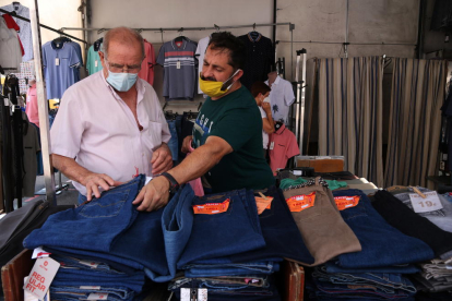 Un paradista y un cliente comprando en uno de los puestos de ropa del mercado de Bonavista que ha reabierto después de tres meses de inactividad.