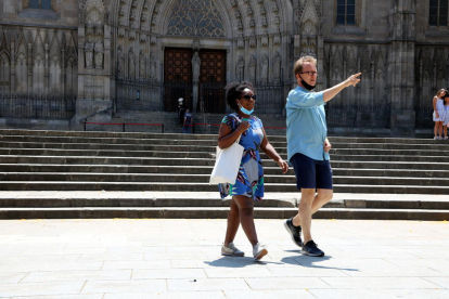 Dos dels pocs turistes que passejaven davant la catedral de Barcelona.