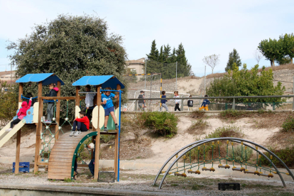 Un grupo de niños jugando en el patio en la zona de juegos de la escuela Cor de Roure de Santa Coloma de Queralt.