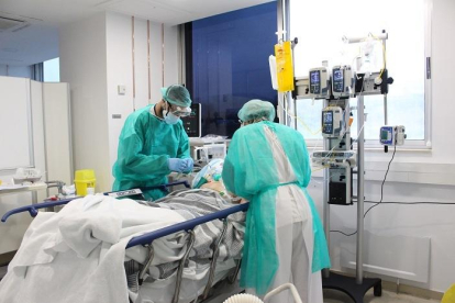 Pla mitjà de dos metges tenint cura d'un pacient amb coronavirus aquest dissabte 18 d'aril de 2020 a l'hospital Trueta. (