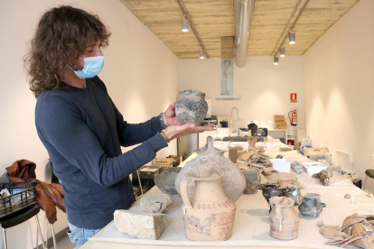L'arqueòleg Dani López mostrant una peca de ceràmica sencera trobada al jaciment Font de la Canya.