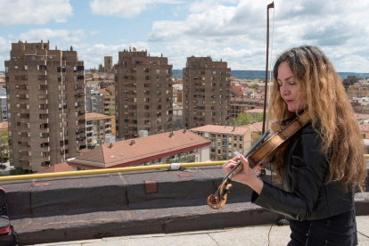 Daniela tocant el violí al terrat.