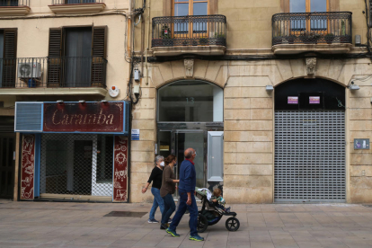 Dos locales cerrados a la calle Sant Agustí de Tarragona con un grupo de personas caminando por delante.