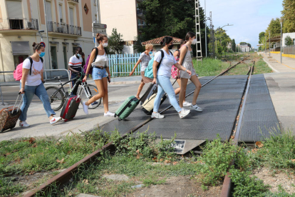 Un grupo de turistas cruzando la antigua vía del tren en el centro de Salou.